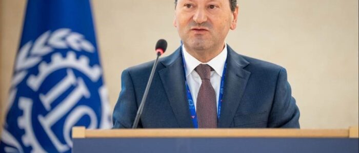 oit JUNHO DE 2024 SET Foto do Secretário de Estado a fazer a sua intervenção no pulpito. Bandeira da OIT no fundo da sala e nas suas costas